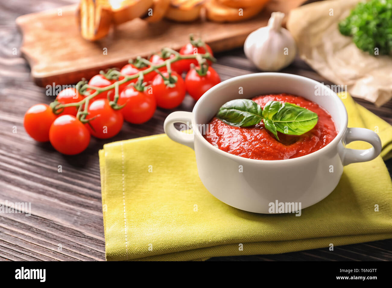 Tureen with tasty tomato sauce on wooden table Stock Photo