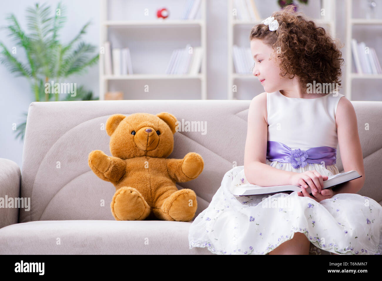 Little pretty girl reading books at home Stock Photo - Alamy