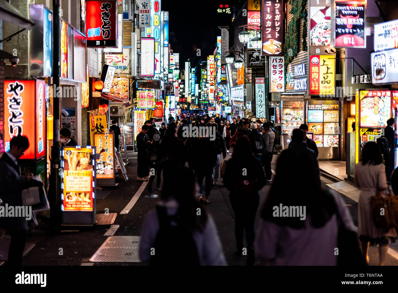 Shinjuku, Japan - April 3, 2019: Famous Kabukicho alley street red light district in downtown city with night with many people walking Stock Photo