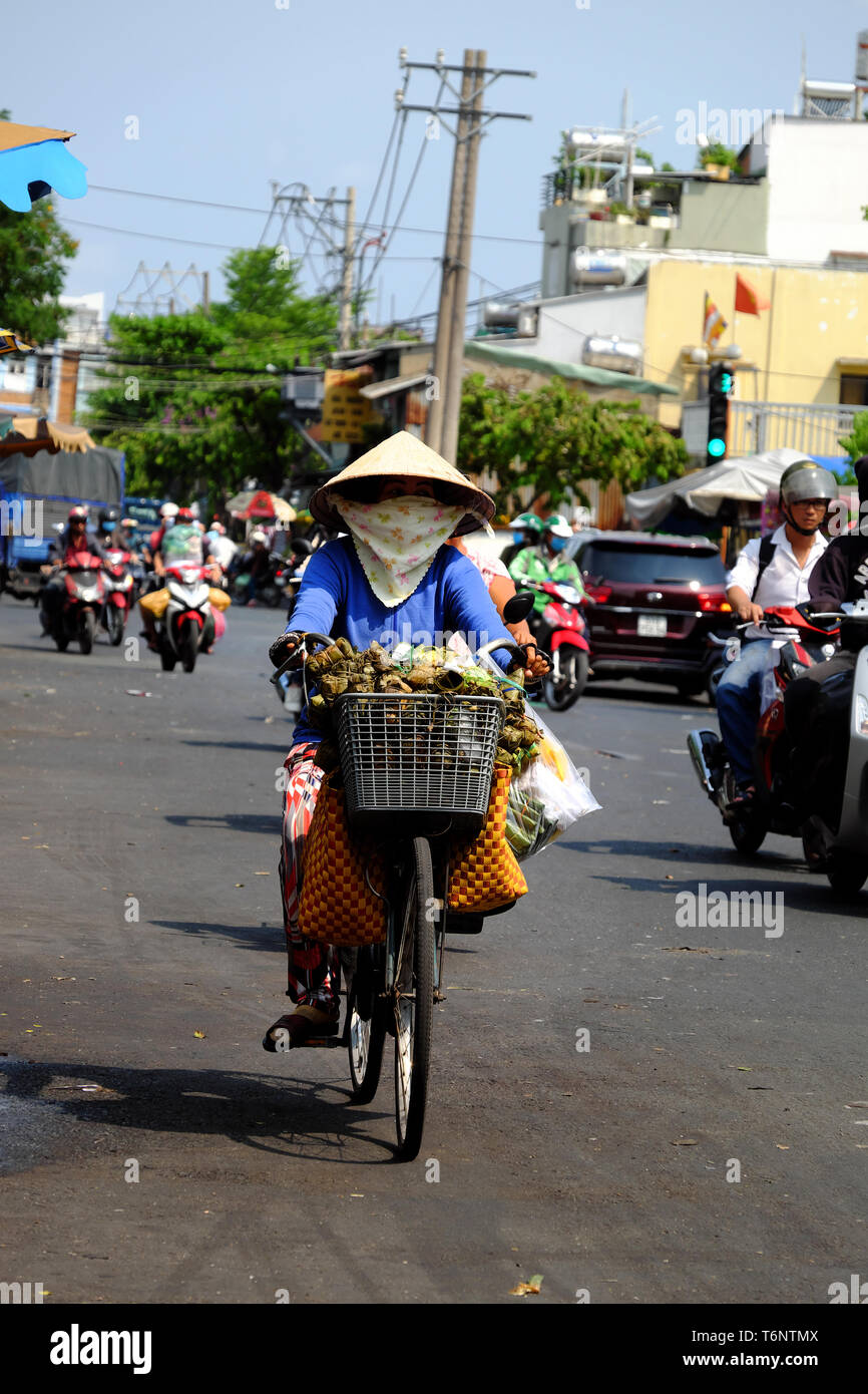 Vietnamese woman wear face mask to sun protection, ride bicycle under ...