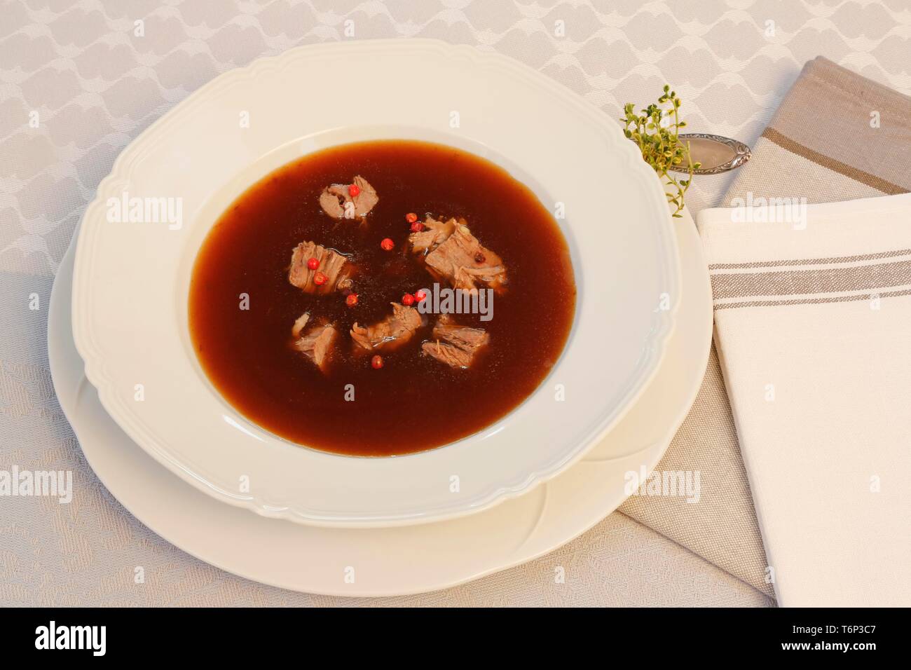 Oxtail soup with red pepper in soup plate, Germany Stock Photo
