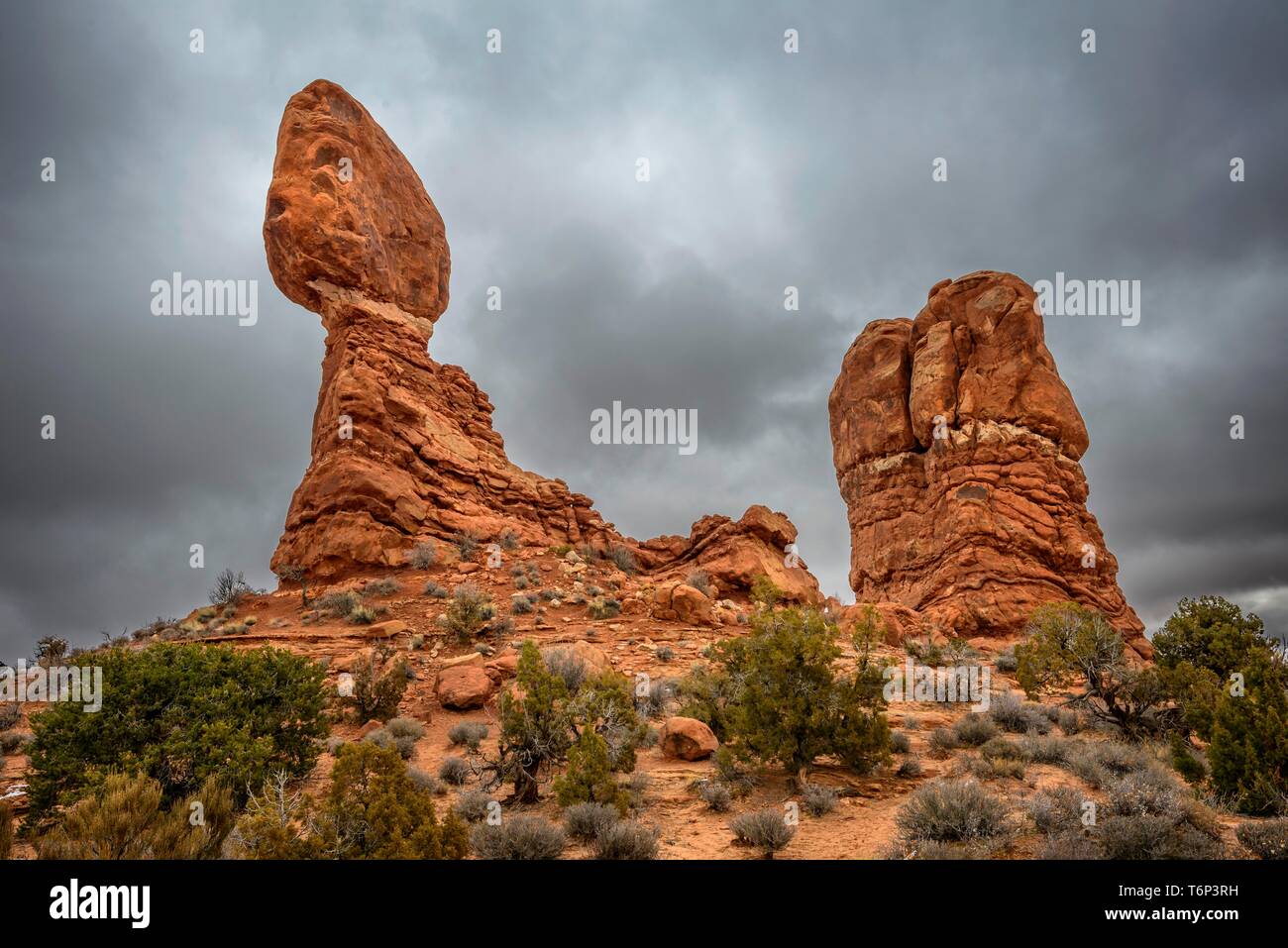 Rock formation Balanced Rock, dark cloudy sky, Arches National Park, near Moab, Utah, USA Stock Photo