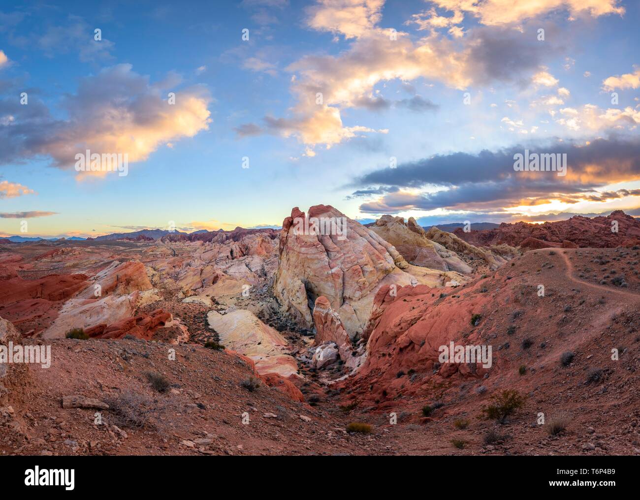 Colorful, red orange rock formations at sunset with colored clouds, White Dome, sandstone rocks, Valley of Fire State Park, Mojave Desert, Nevada, USA Stock Photo