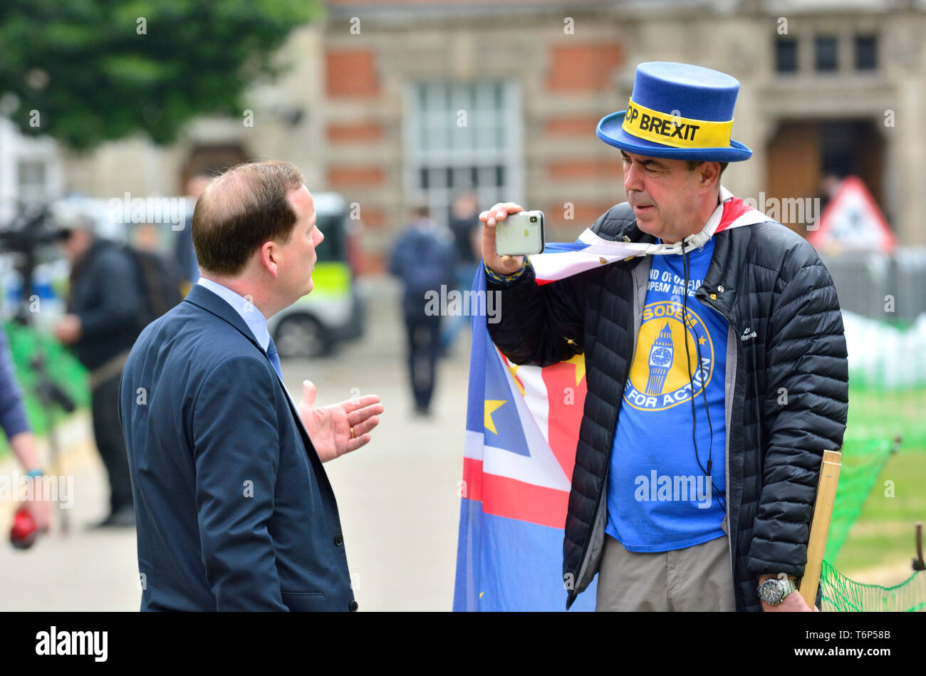 Charlie Elphicke MP (Con: Dover) being interviewed by Steve Bray, anti-Brexit protester, on College Green, Westminster, London Stock Photo