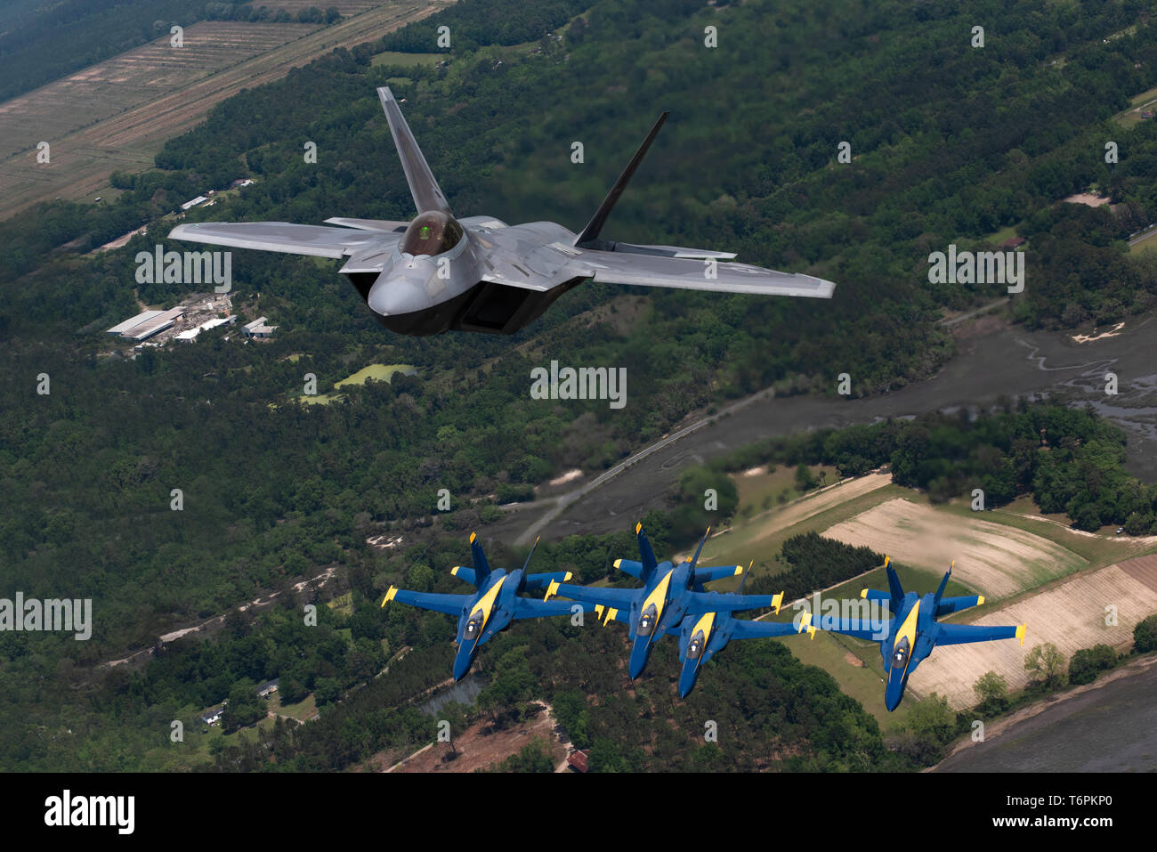 U.S. Air Force Maj. Paul 'Loco' Lopez, F-22 Demo Team commander/pilot, flies above the U.S. Navy Blue Angels' in Beaufort, South Carolina, April 25, 2019. This historic flight featured two of the world's premier aerial demonstration teams side-by-side in various formations. (U.S. Air Force photo by 2nd Lt. Samuel Eckholm)  Stock Photo