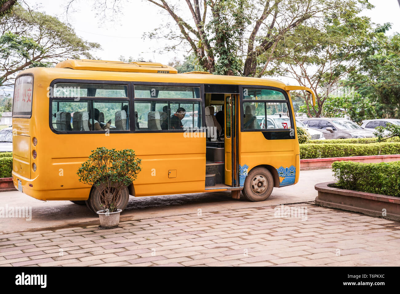 Ton Pheung district, Laos - 13 January 2018, Yellow Laos bus waiting for passengers at Golden triangle special economic zone. Stock Photo