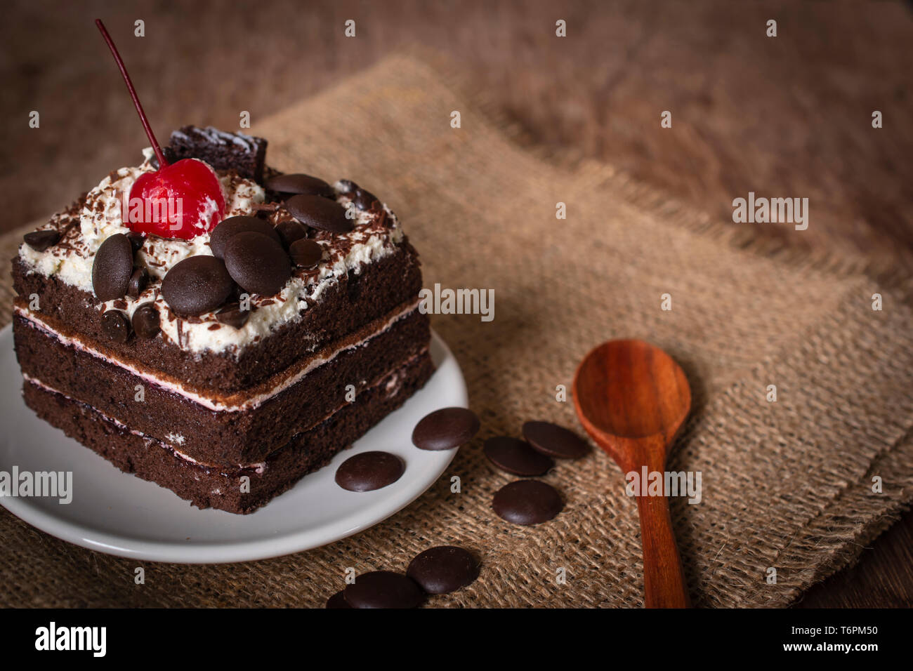 Black Forest Cake Topping Cherry Putting On The White Plate On The Sack And Wood Background There Are Wood Spoon And Chocolate Grain Placed Beside Stock Photo Alamy