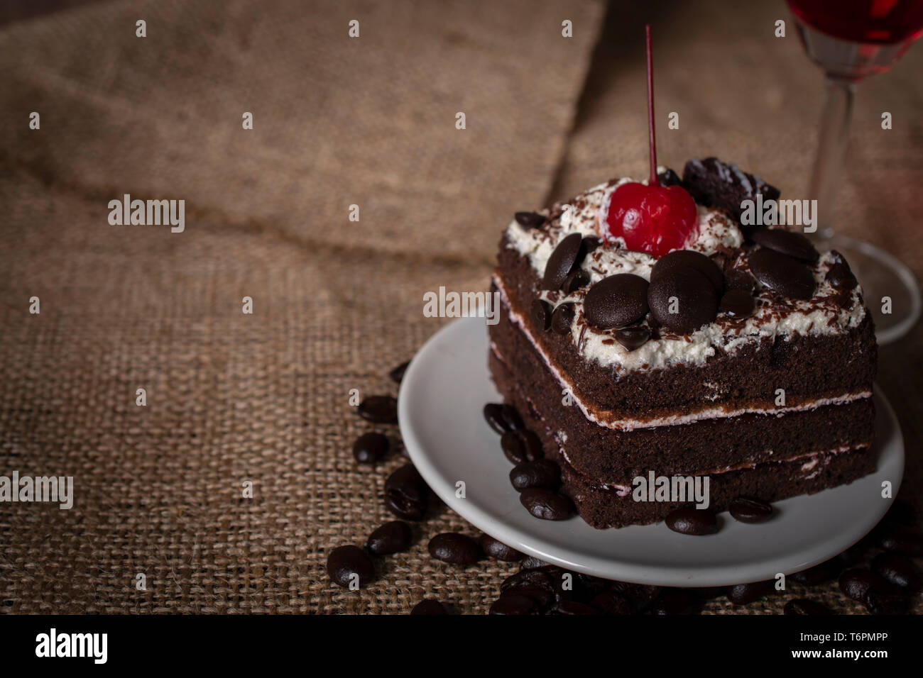 Black Forest Cake Topping Cherry Putting On The White Plate And Coffee Beans Placed Beside It Glass Placed Behind On The Sack Bags Background Stock Photo Alamy Black Forest Cake Topping Cherry Putting On The White Plate And Coffee Beans Placed Beside It Glass Placed Behind On The Sack Bags Background Stock Photo Alamy