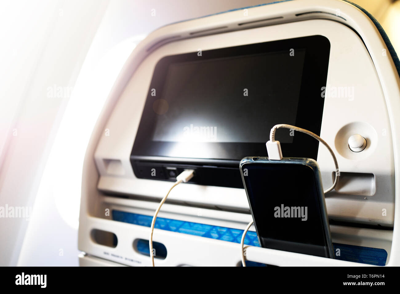 Passenger on a plane using the charger for charge smart phone during