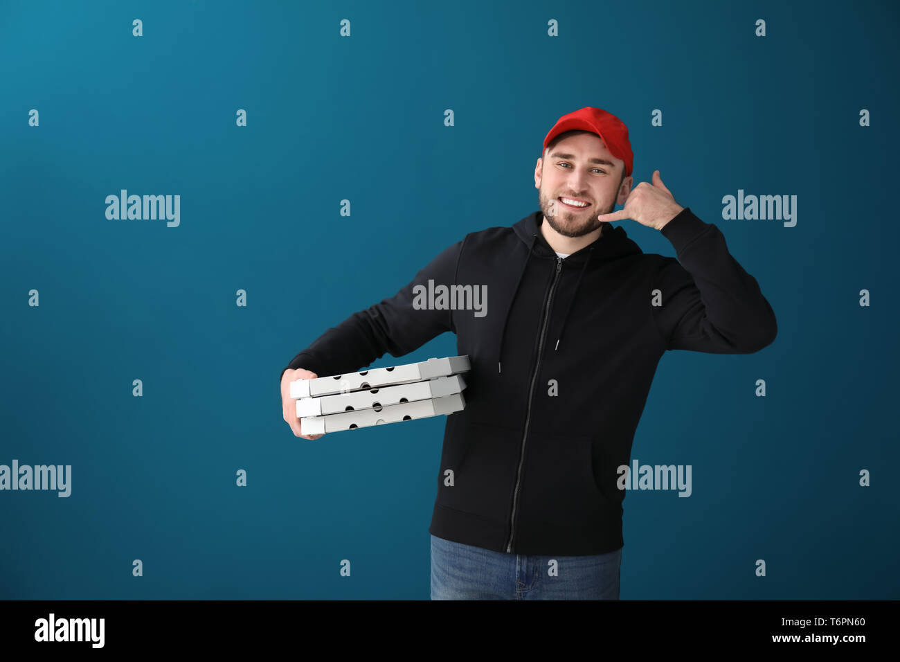 Young man with cardboard pizza boxes on color background. Food delivery service Stock Photo