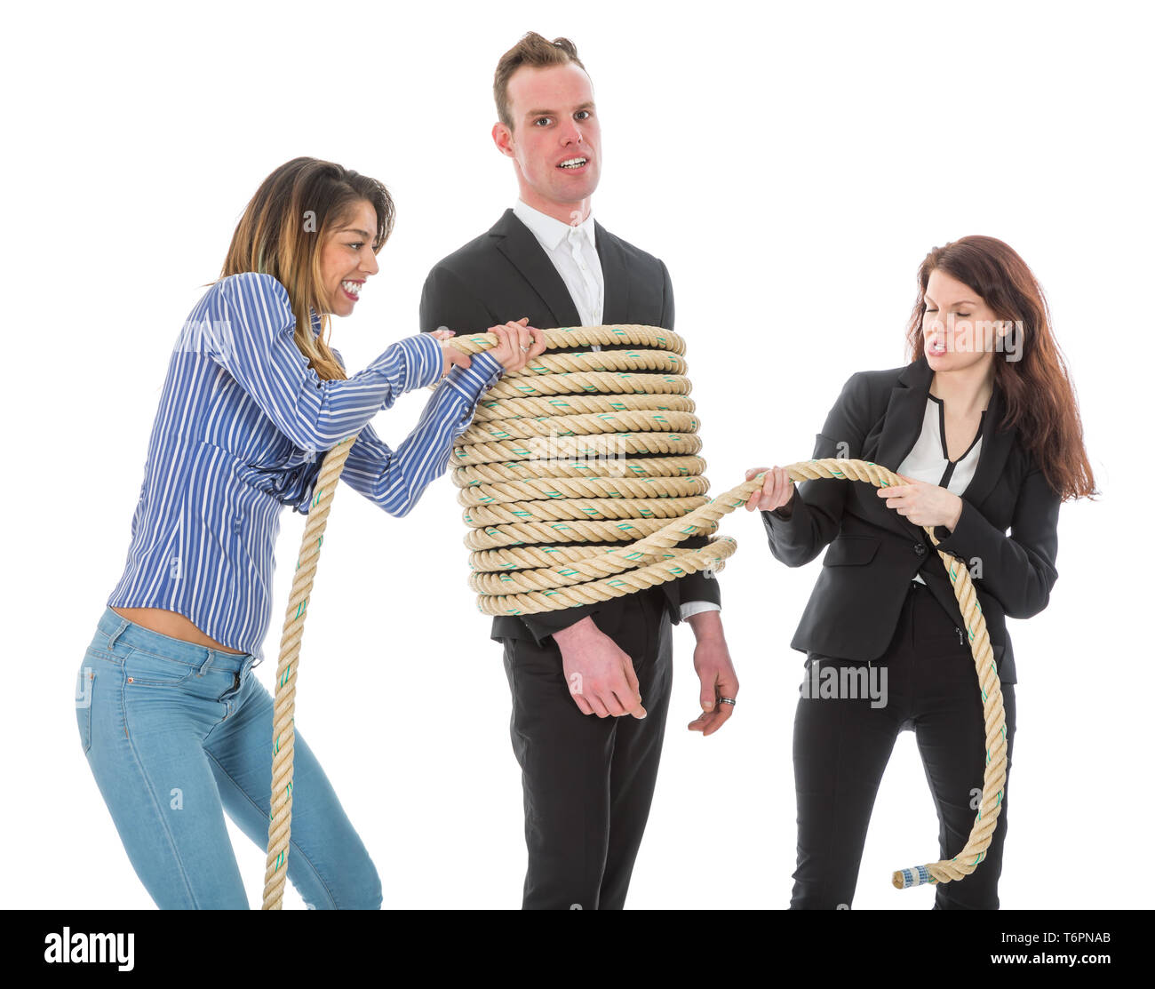 Two angry woman tying a business man with rope Stock Photo - Alamy