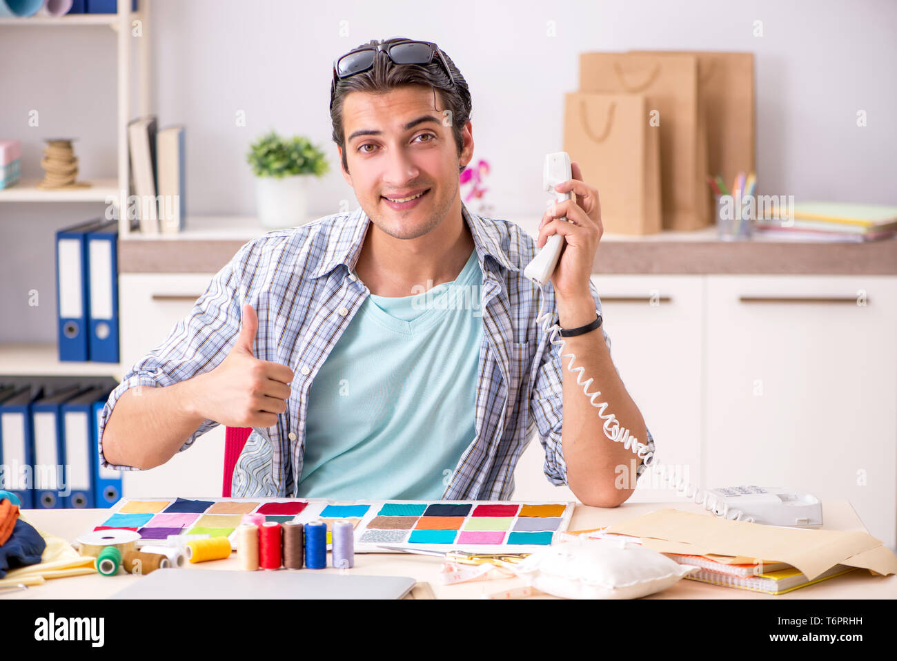 Young handsome tailor working in his workshop Stock Photo
