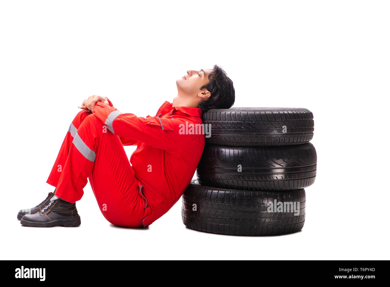 Young garage worker with tyre isolated on white Stock Photo