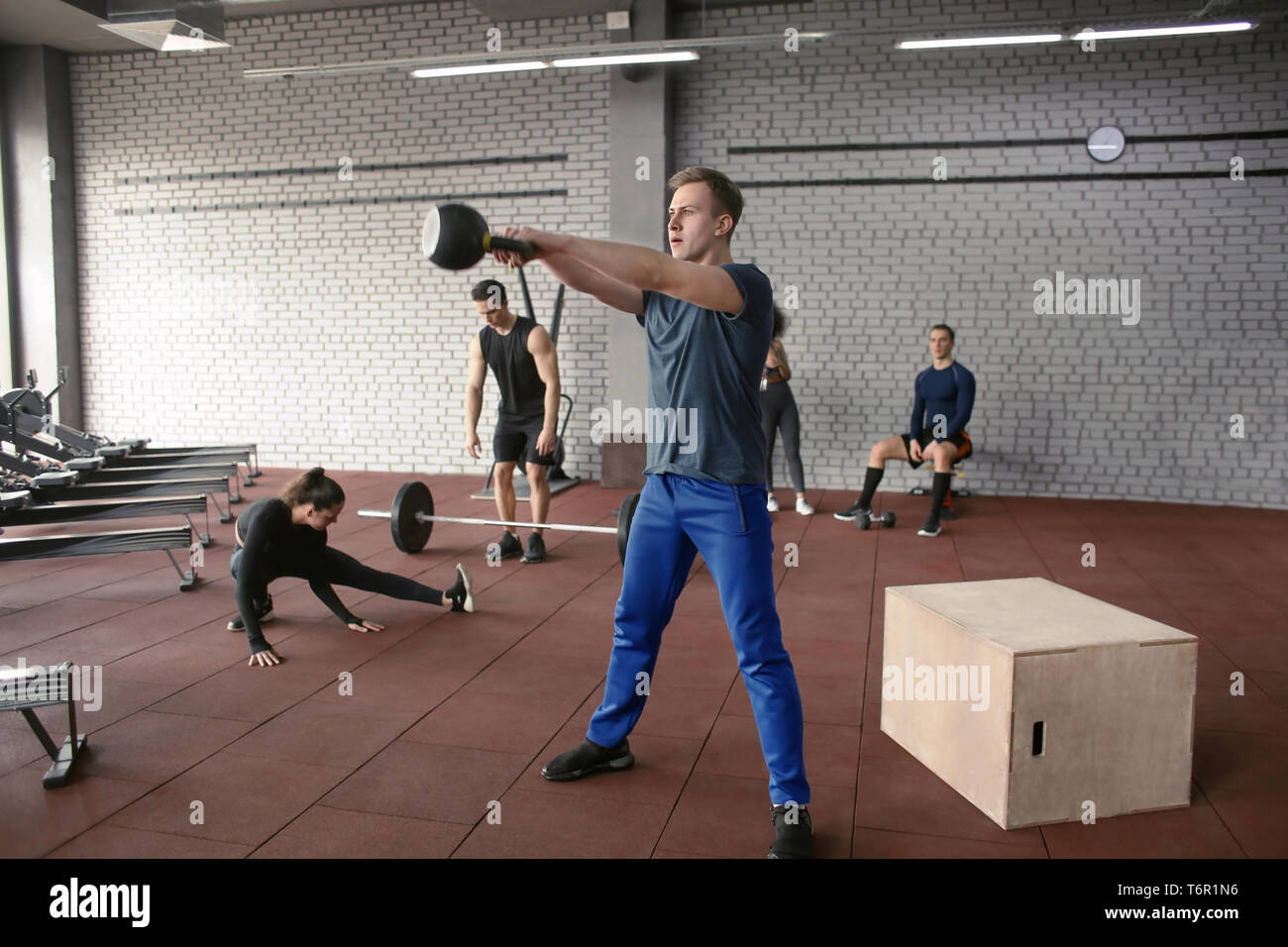 Athletic man doing exercises with kettlebell in modern gym Stock Photo