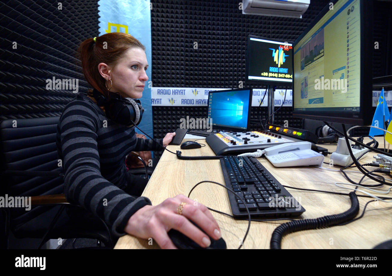 Sound engineer sitting in front of monitor at the radio studio. Kiev