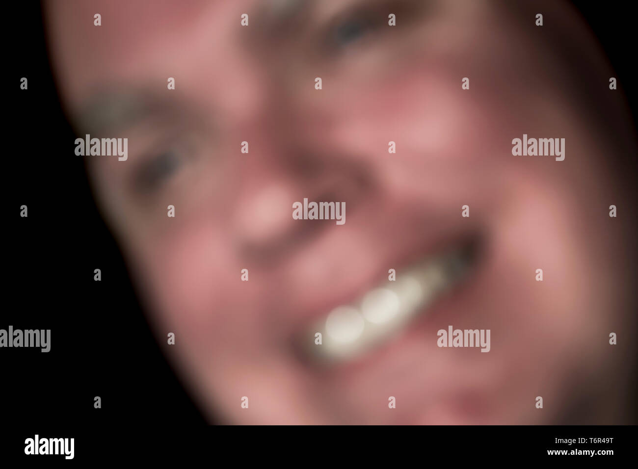 Blurred abstract image of a man with a happy, content, smiling face. Blurry image showing concept of happiness and contentment. Stock Photo