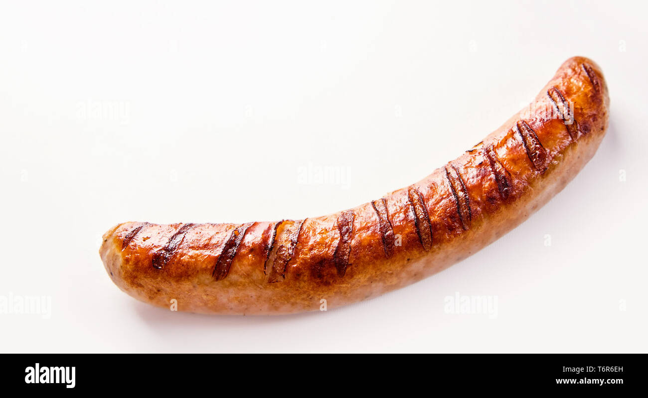 Side view of curved single German bratwurst sausage on white background