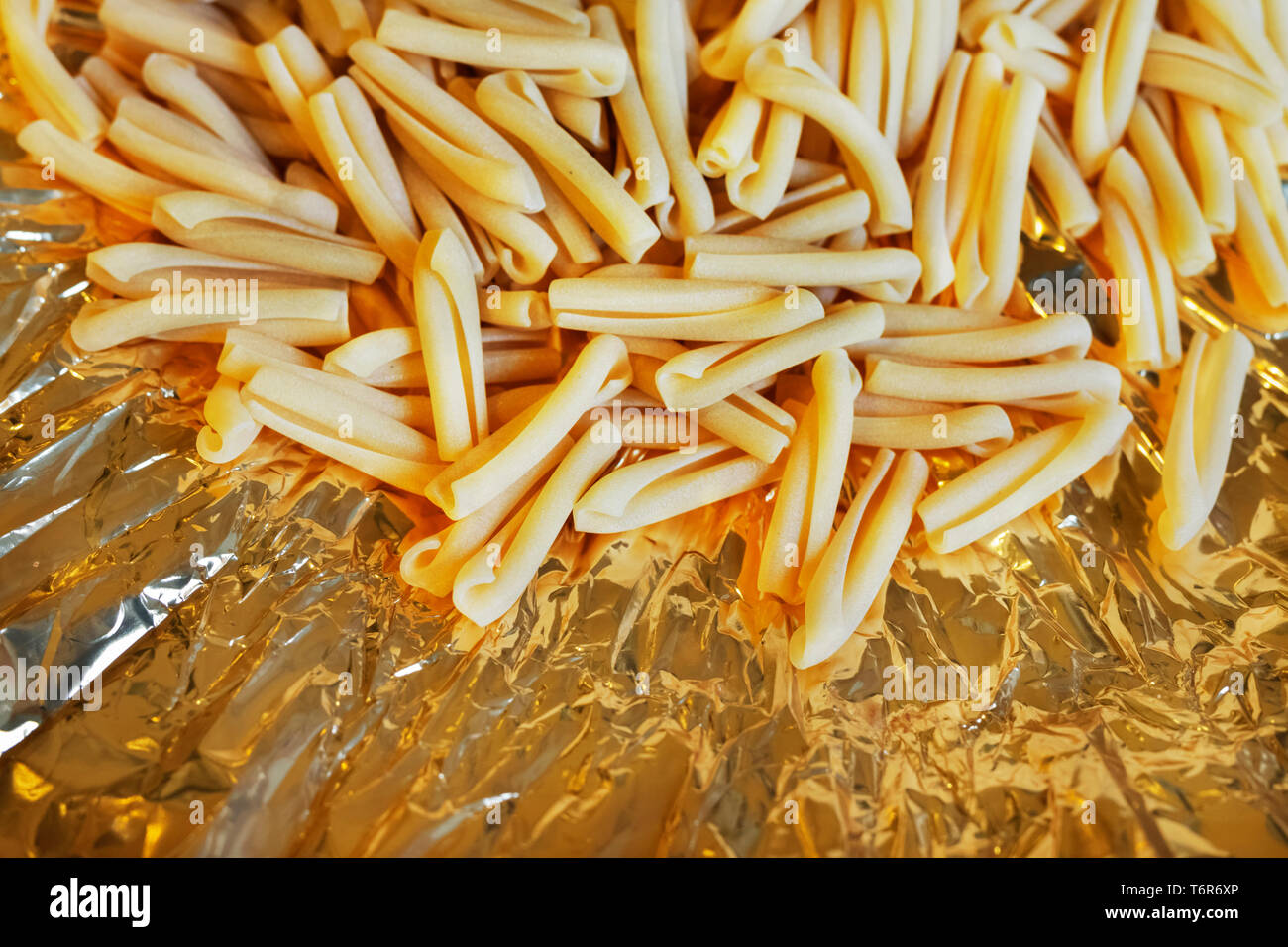https://c8.alamy.com/comp/T6R6XP/italian-pasta-casarecce-on-a-colored-background-short-and-twist-pasta-shape-T6R6XP.jpg