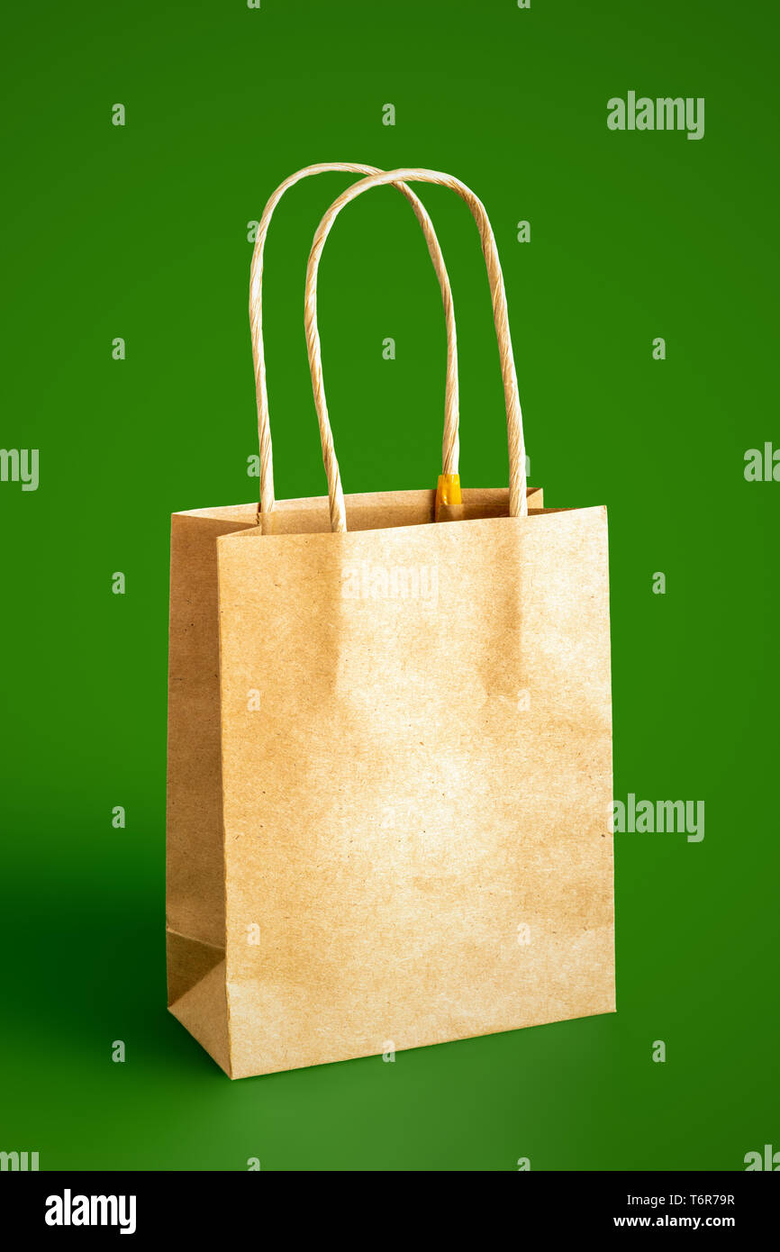 beige paper bag isolated on green background Stock Photo
