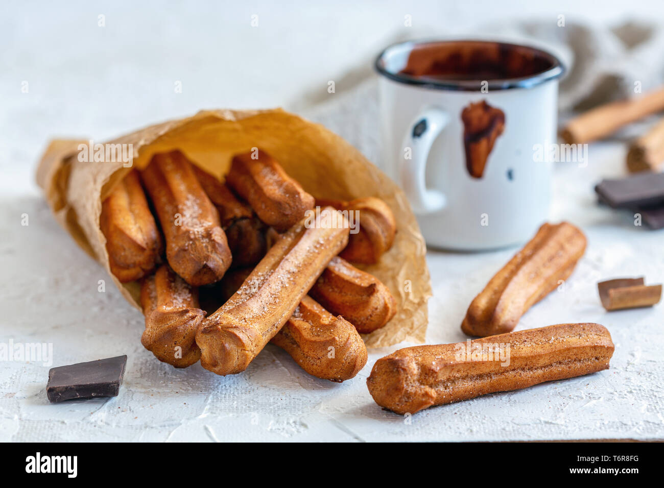 Churros with cinnamon and sugar in a paper bag. Stock Photo