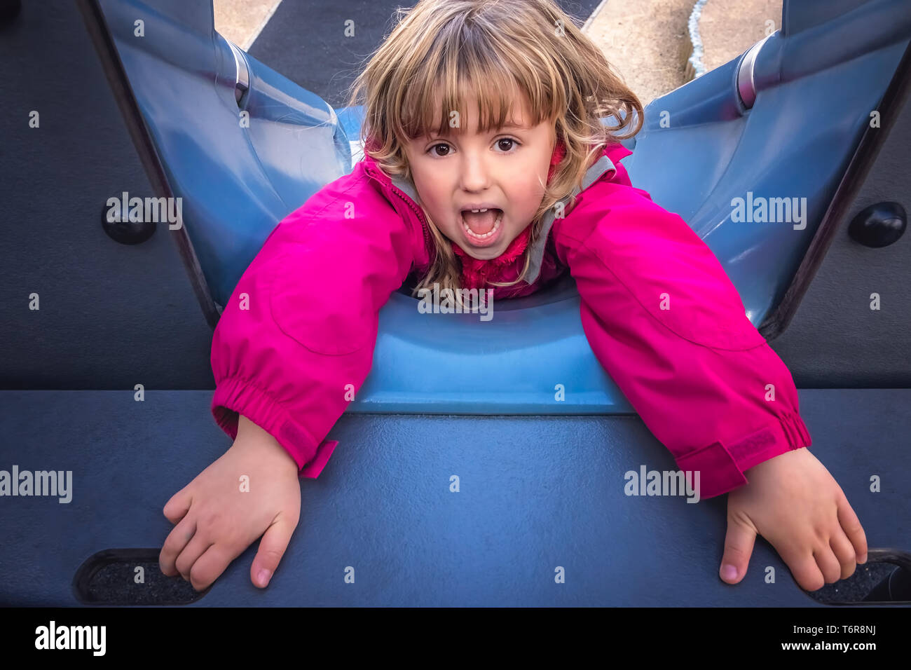 Girl falling down the slide Stock Photo