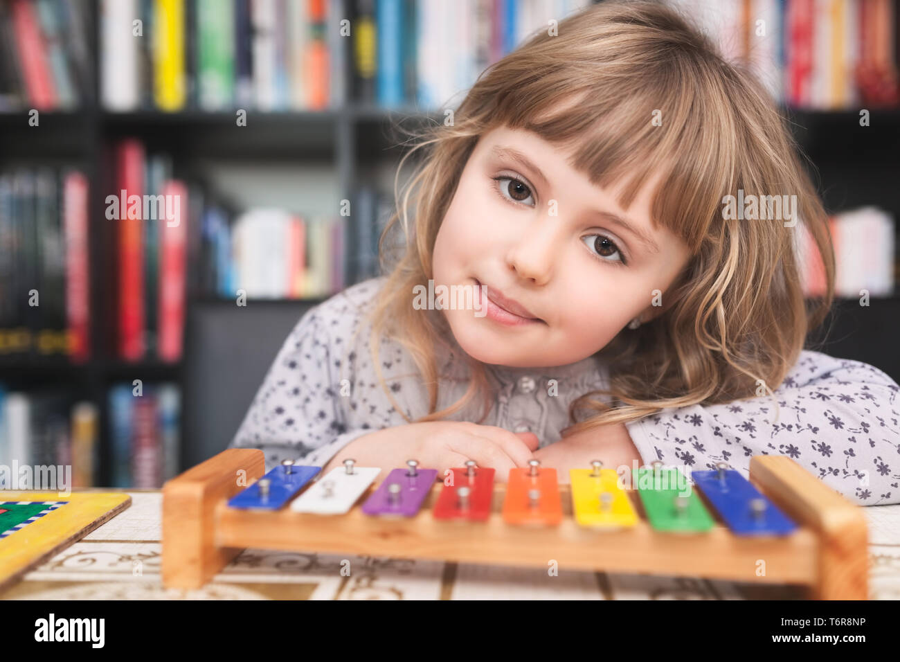 Cute little girl playing colorful cymbals Stock Photo