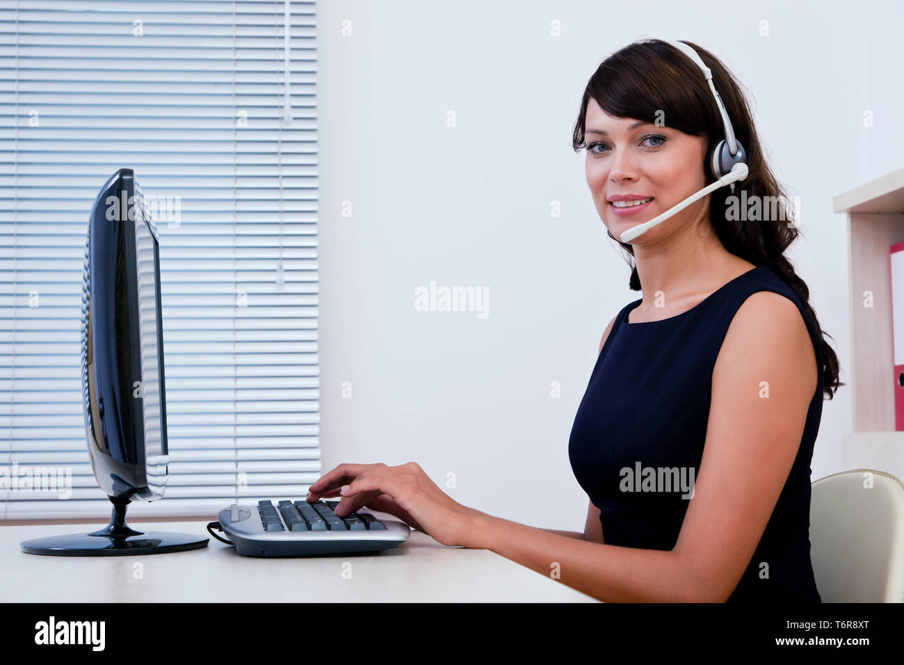 Call centre executive working on computer and interacting Stock Photo