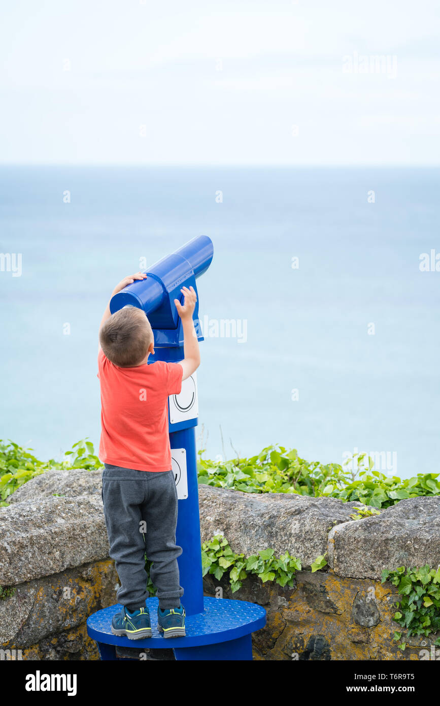 Little boy looking through the telescope Stock Photo - Alamy