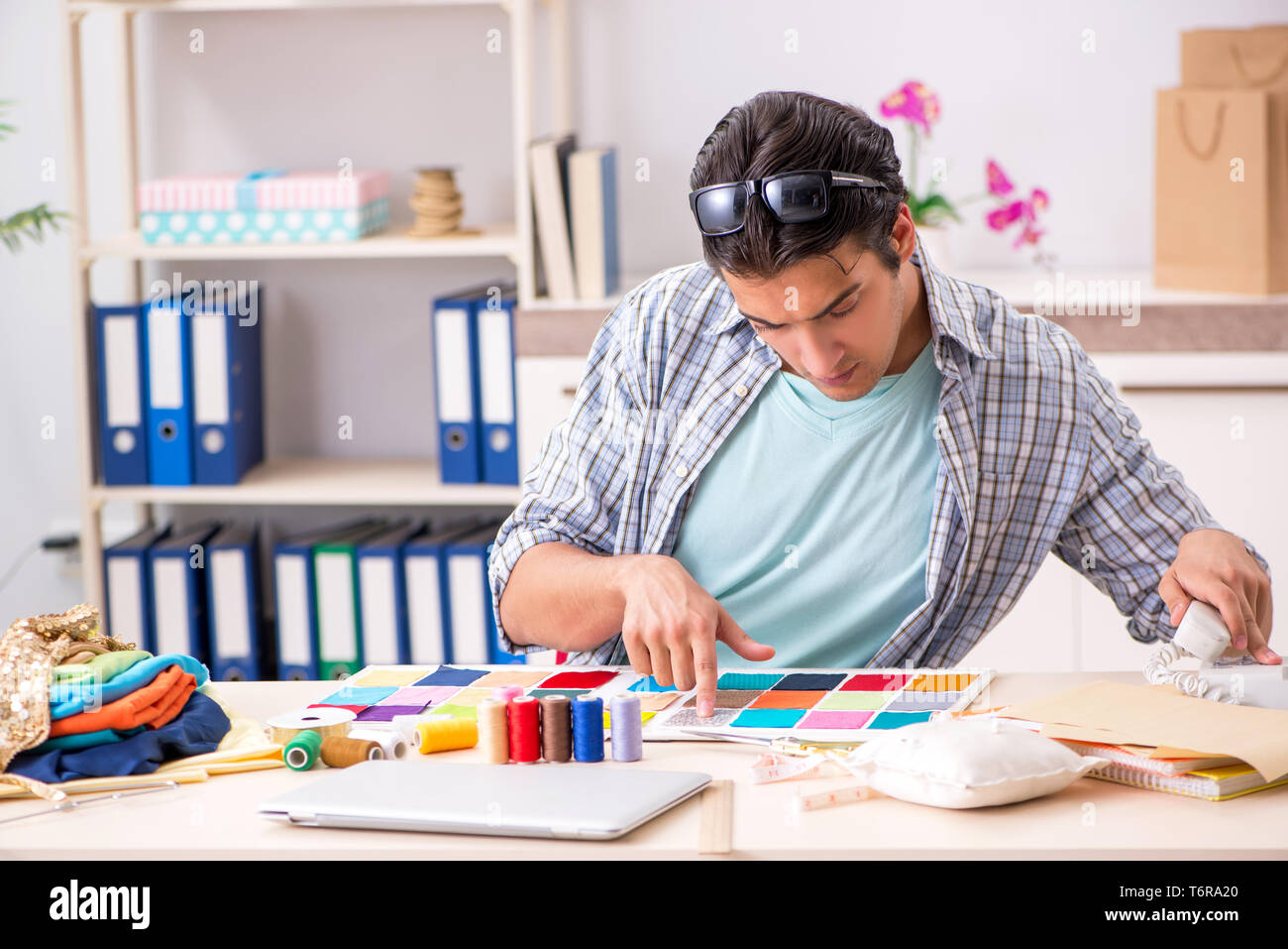 Young handsome tailor working in his workshop Stock Photo