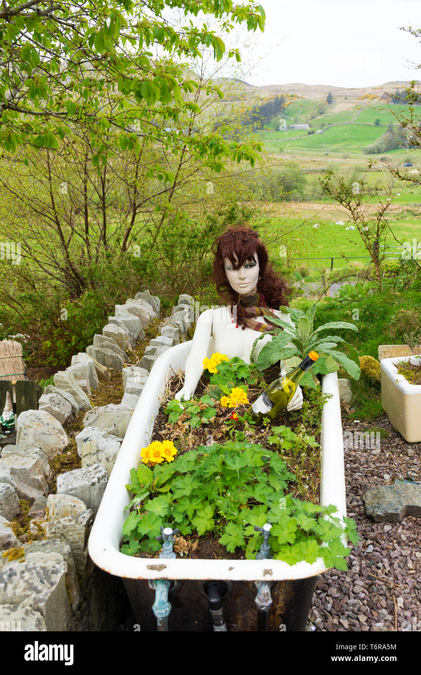 Woman in bath with flowers and wine conceptual art sculpture project, County Donegal, Ireland Stock Photo