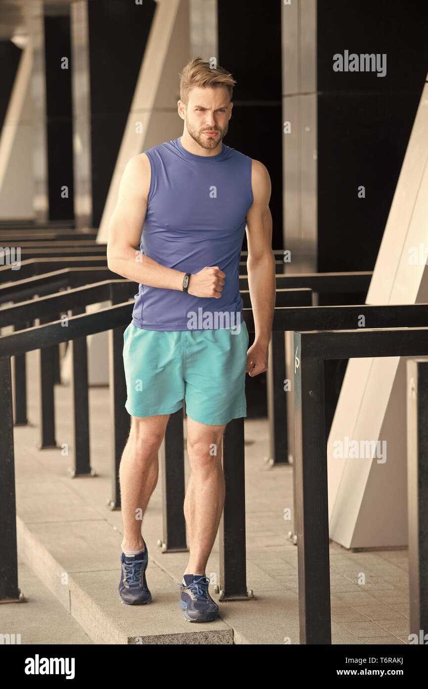 On way to success. Sportsman training with pedometer gadget at stadium ...