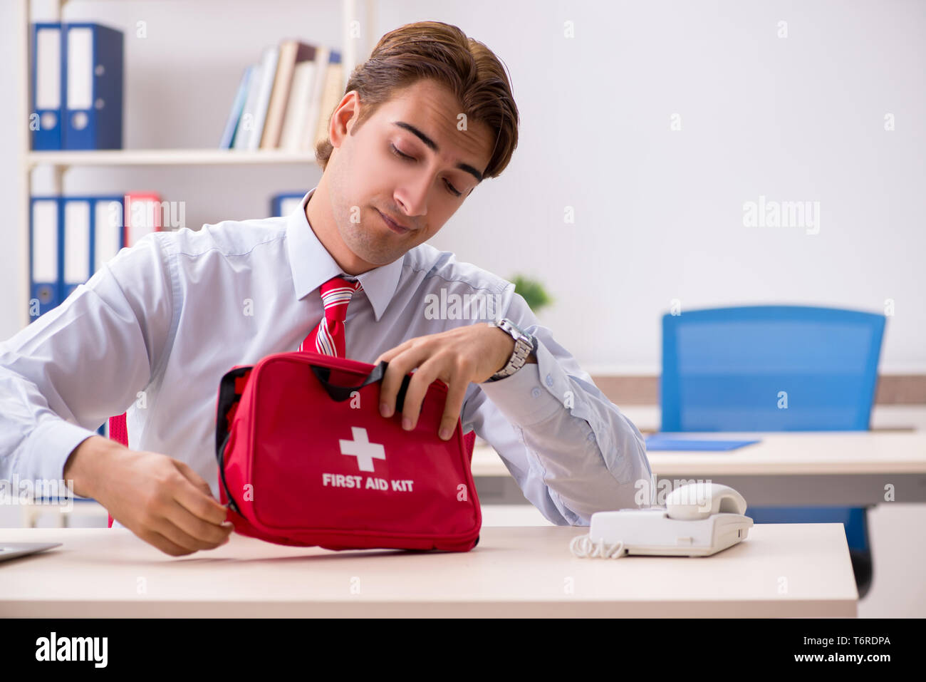 Man with first aid kit in the office Stock Photo - Alamy