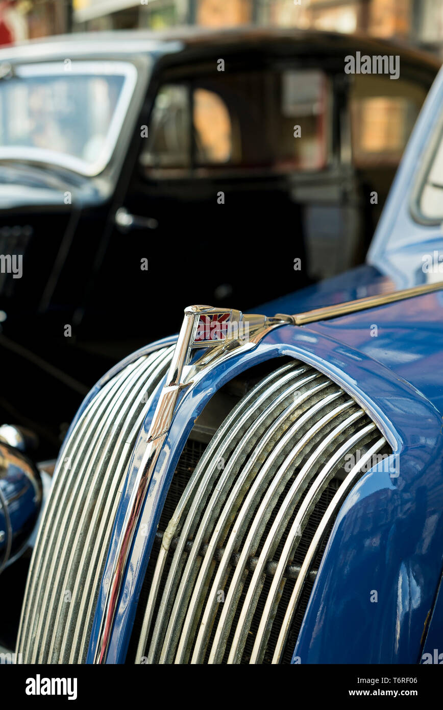 Close up of union jack bonnet (hood) ornament and front radiator grille of classic, vintage motor car, polished and on display at 1940's event, UK. Stock Photo