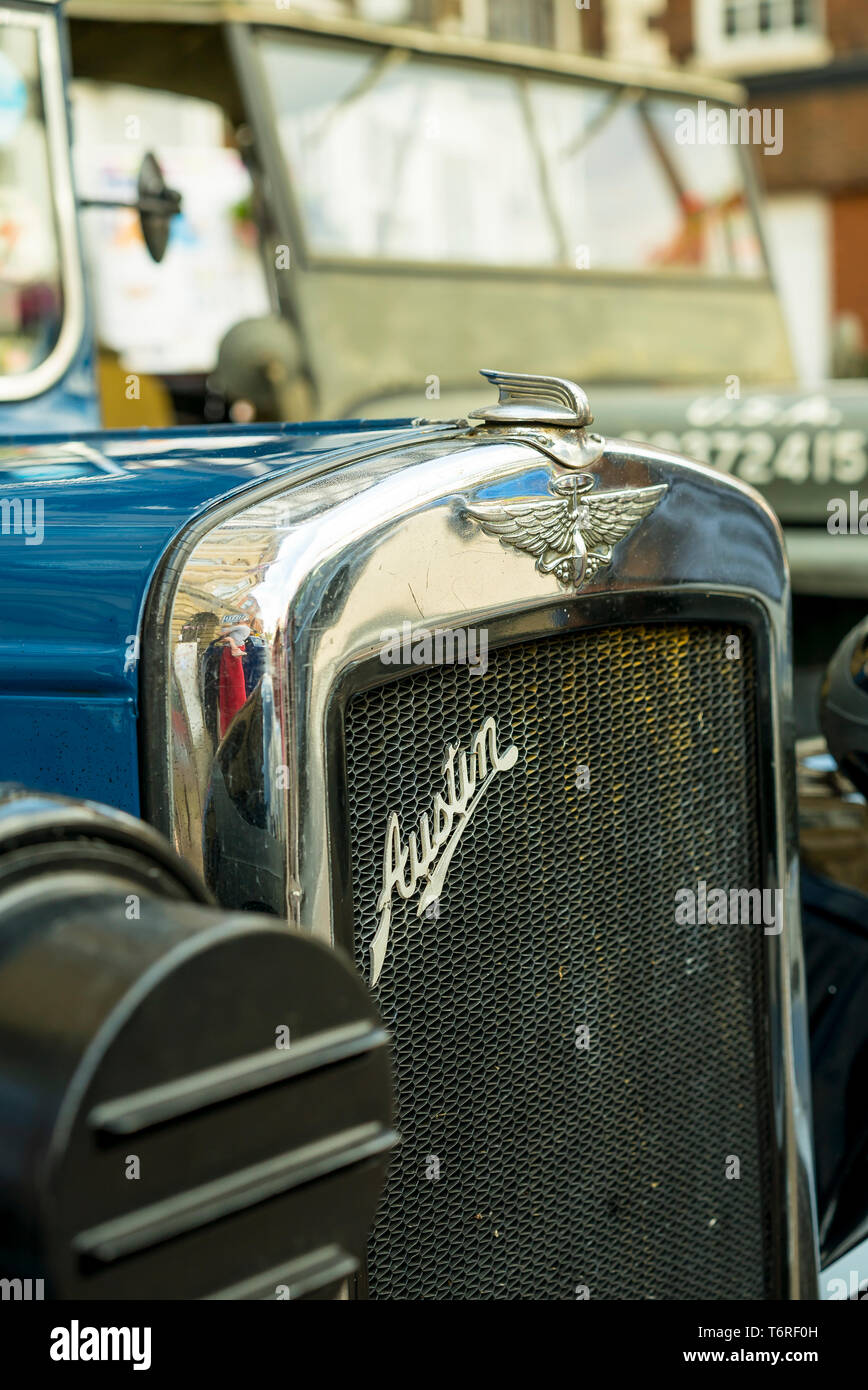 Detailed close-up, front view of old, classic, vintage Austin motor car showing Austin Motor Company emblem on front radiator grille & bonnet ornament. Stock Photo
