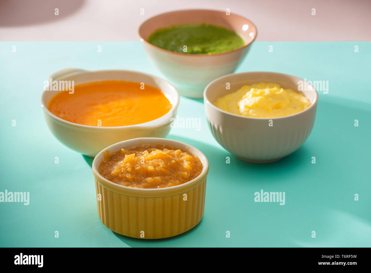 Bowls with baby food. Various bowls of fruit and vegetable puree with