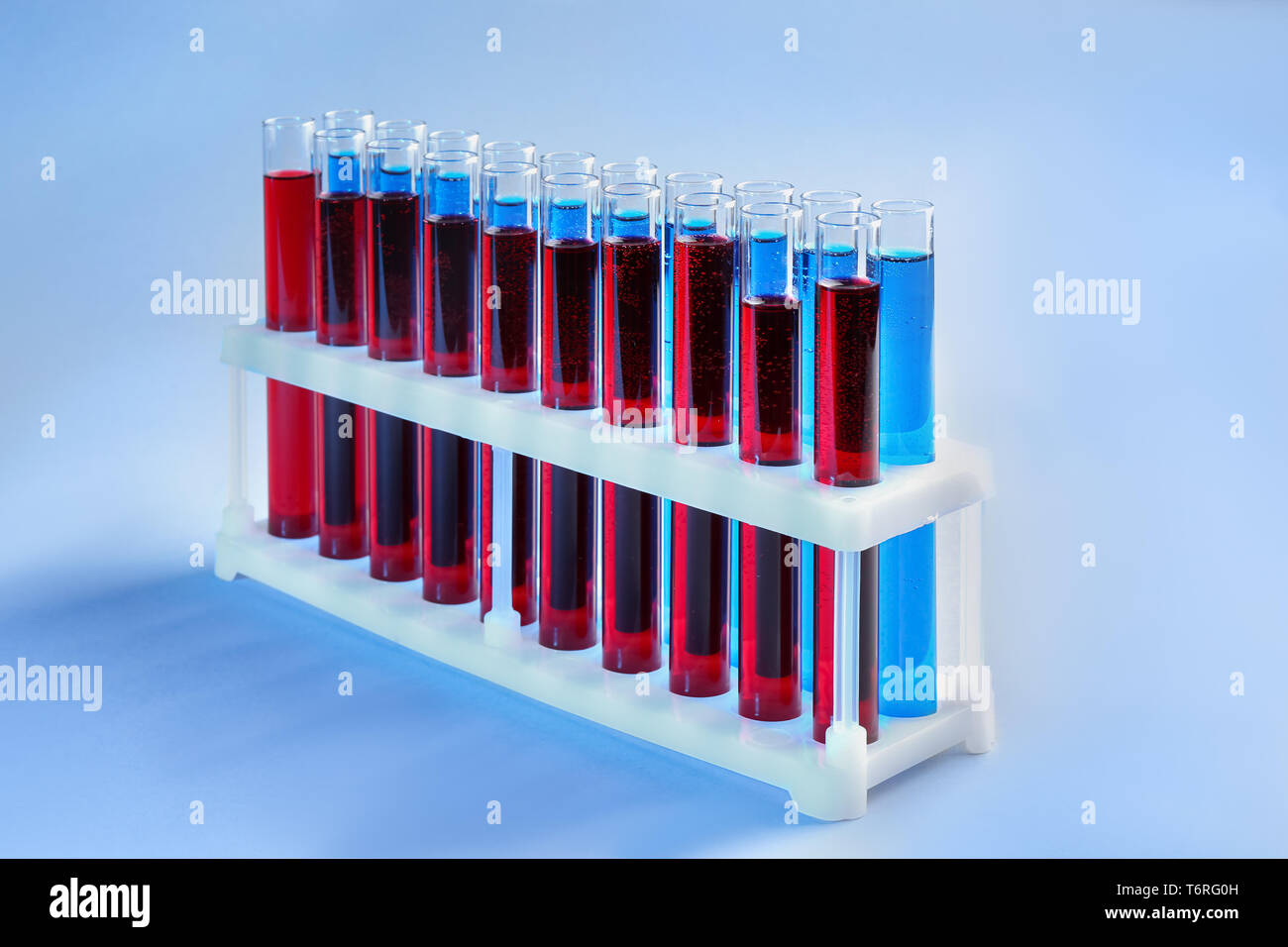 Test tubes with different liquids in holder on color background Stock ...