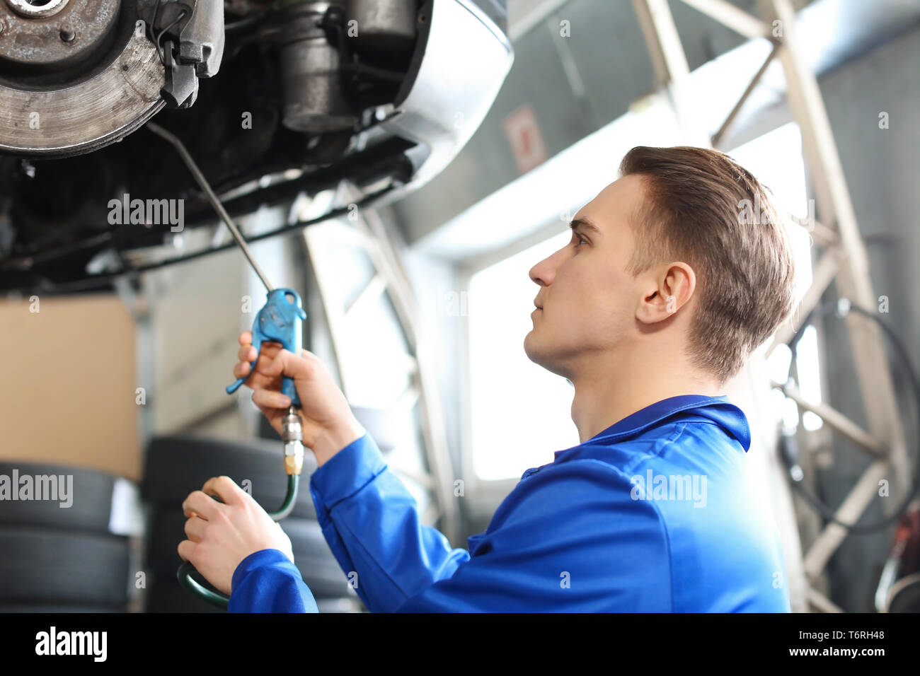 Male mechanic lubricating car in service center Stock Photo Alamy