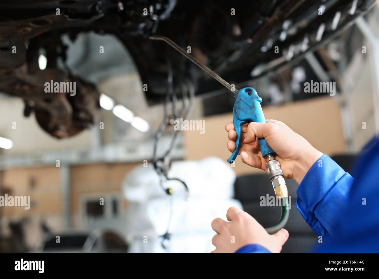 Male mechanic lubricating car in service center Stock Photo Alamy