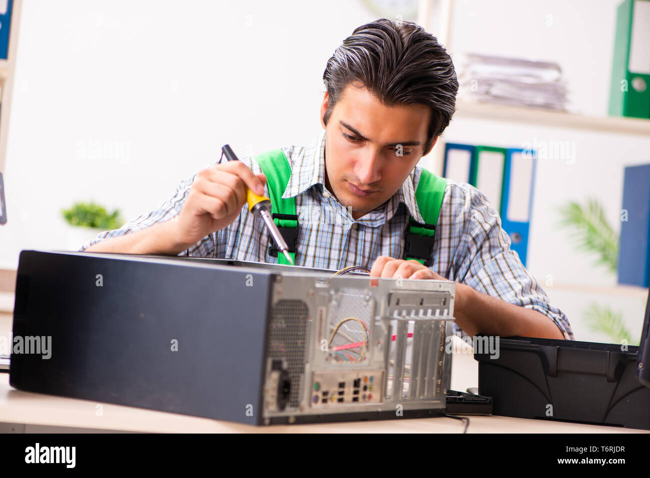 Young engineer repairing broken computer at the office Stock Photo - Alamy