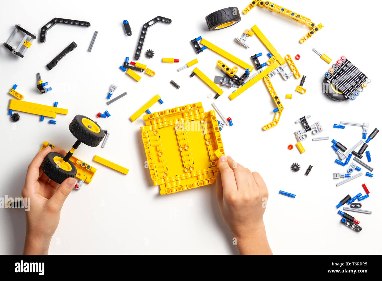 Kid hands making new robot car on white table Stock Photo