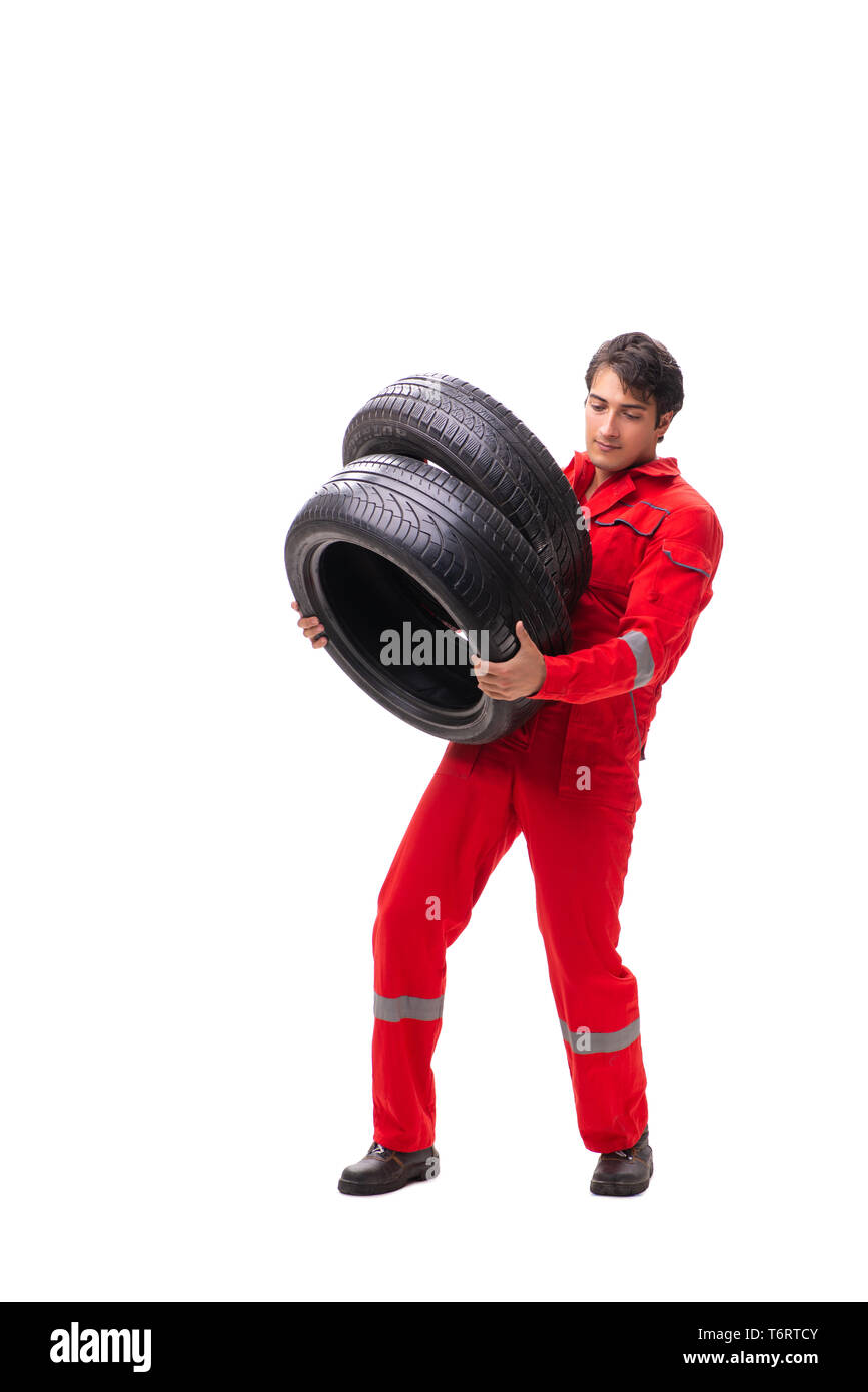 Young garage worker with tyre isolated on white Stock Photo