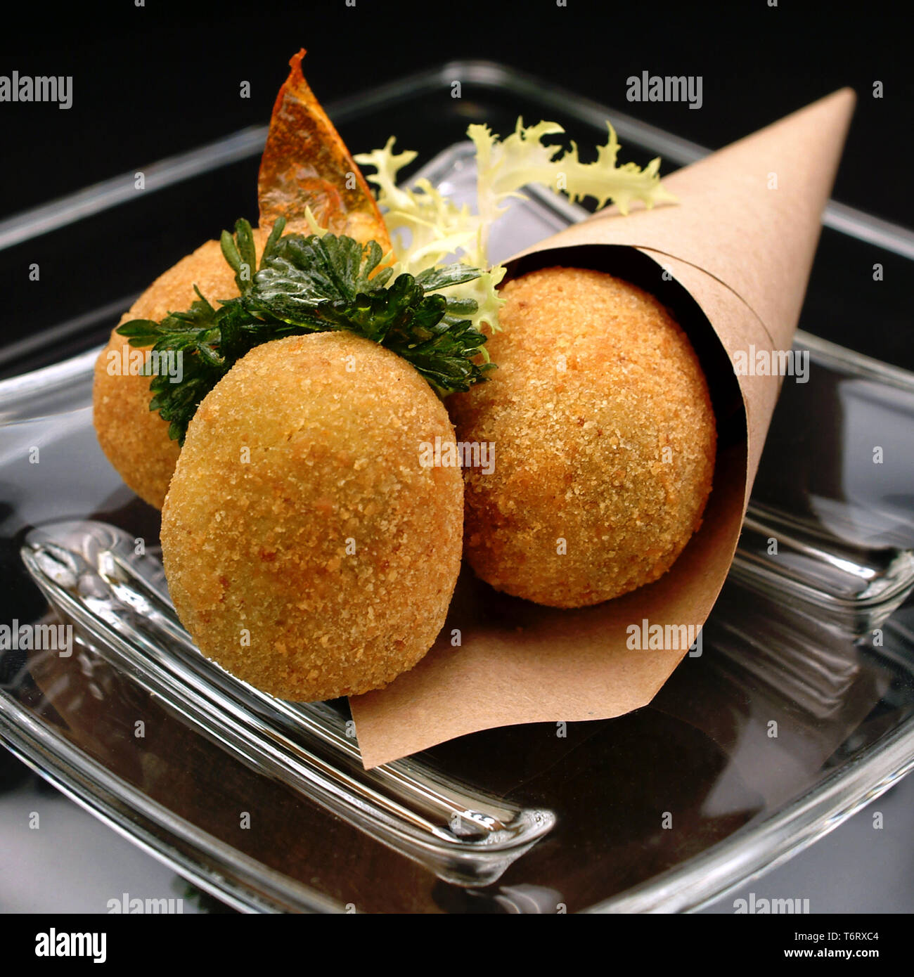 Italian Food Recipes, Olive all'ascolana in cornet in a glass dish. Typical  Italian street-food appetizer with breaded fried olives stuffed of meat. Stock Photo