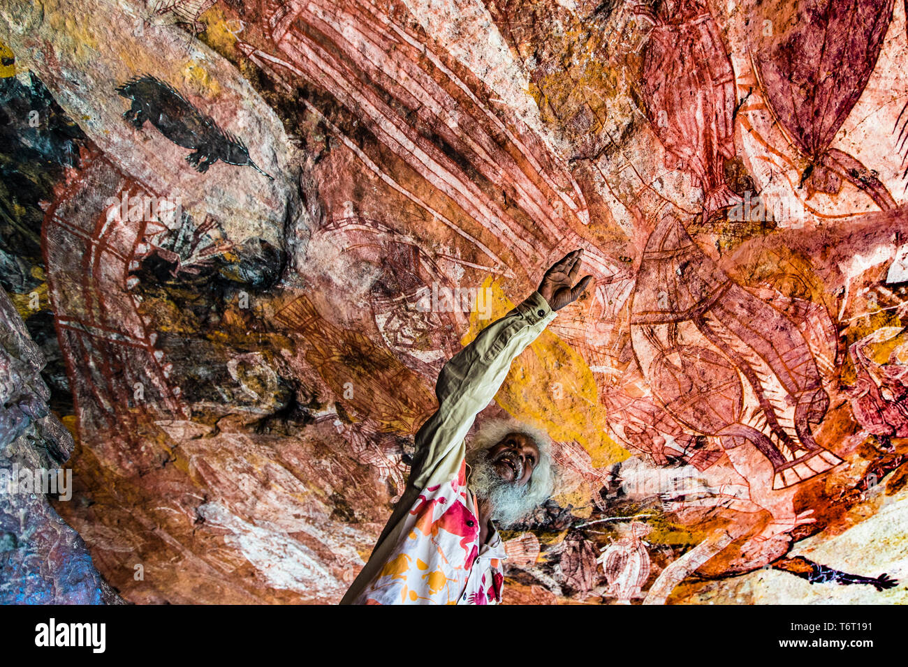 Native Guide explaining Aborigine Rock Art in Long Tom Dreaming, Gunbalanya, Australia Stock Photo