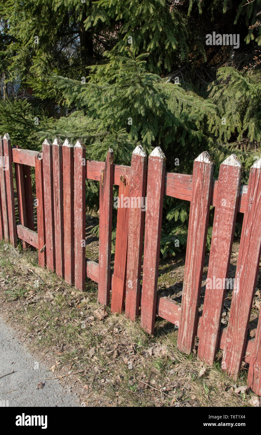 Broken red picket fence Stock Photo