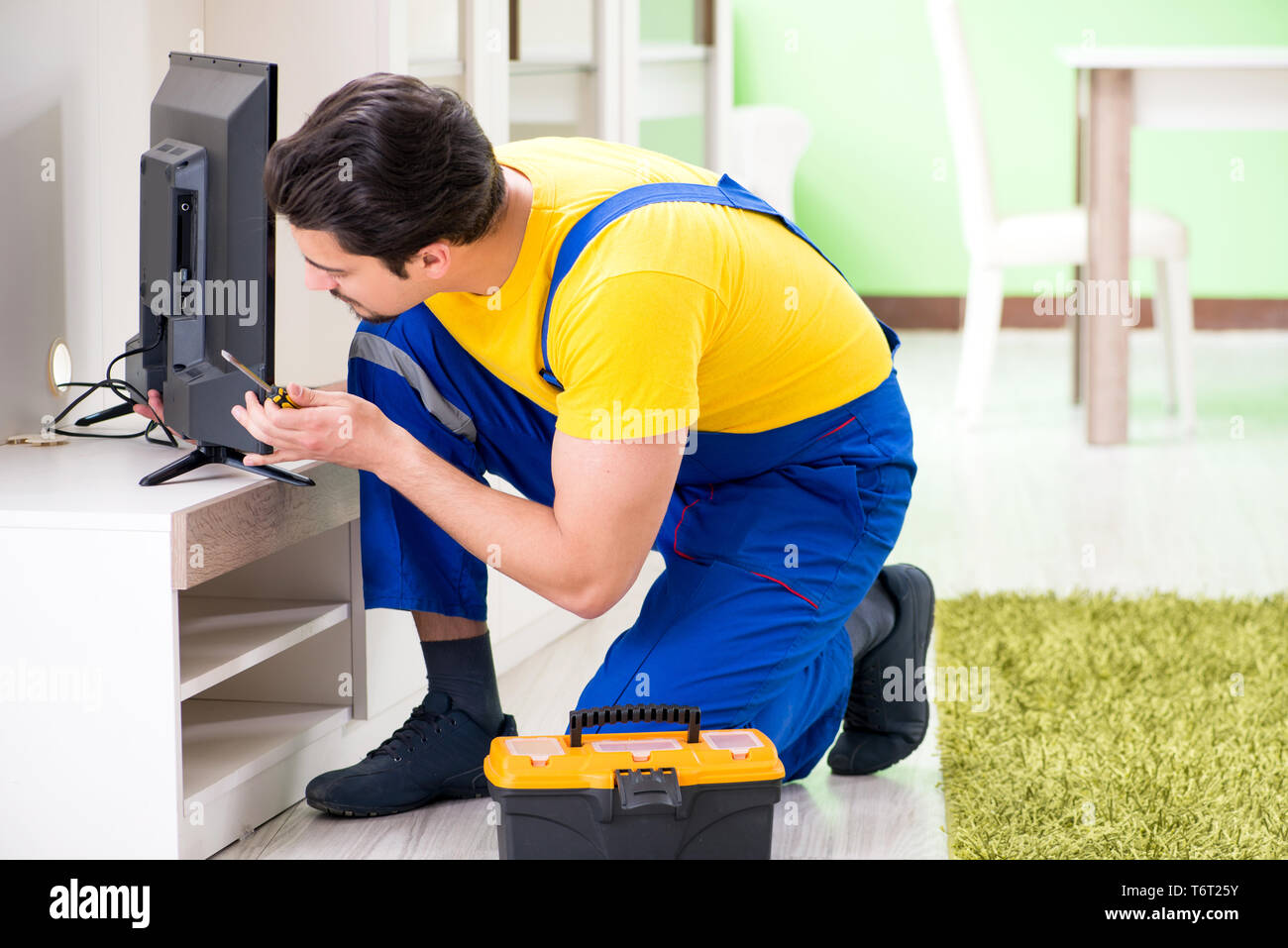Male professional serviceman repairing tv at home Stock Photo - Alamy