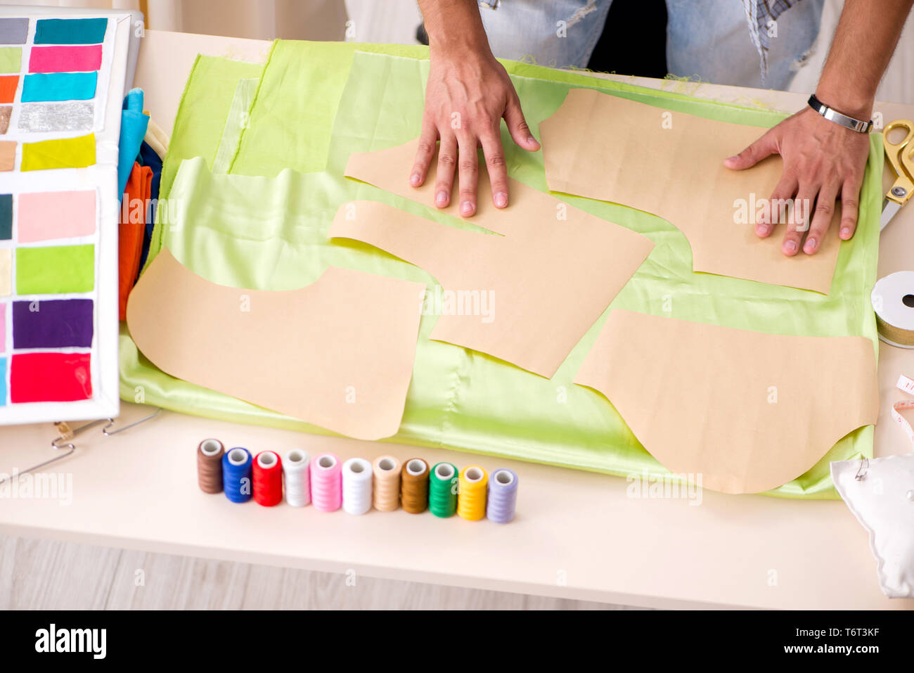 Young handsome tailor working in his workshop Stock Photo - Alamy