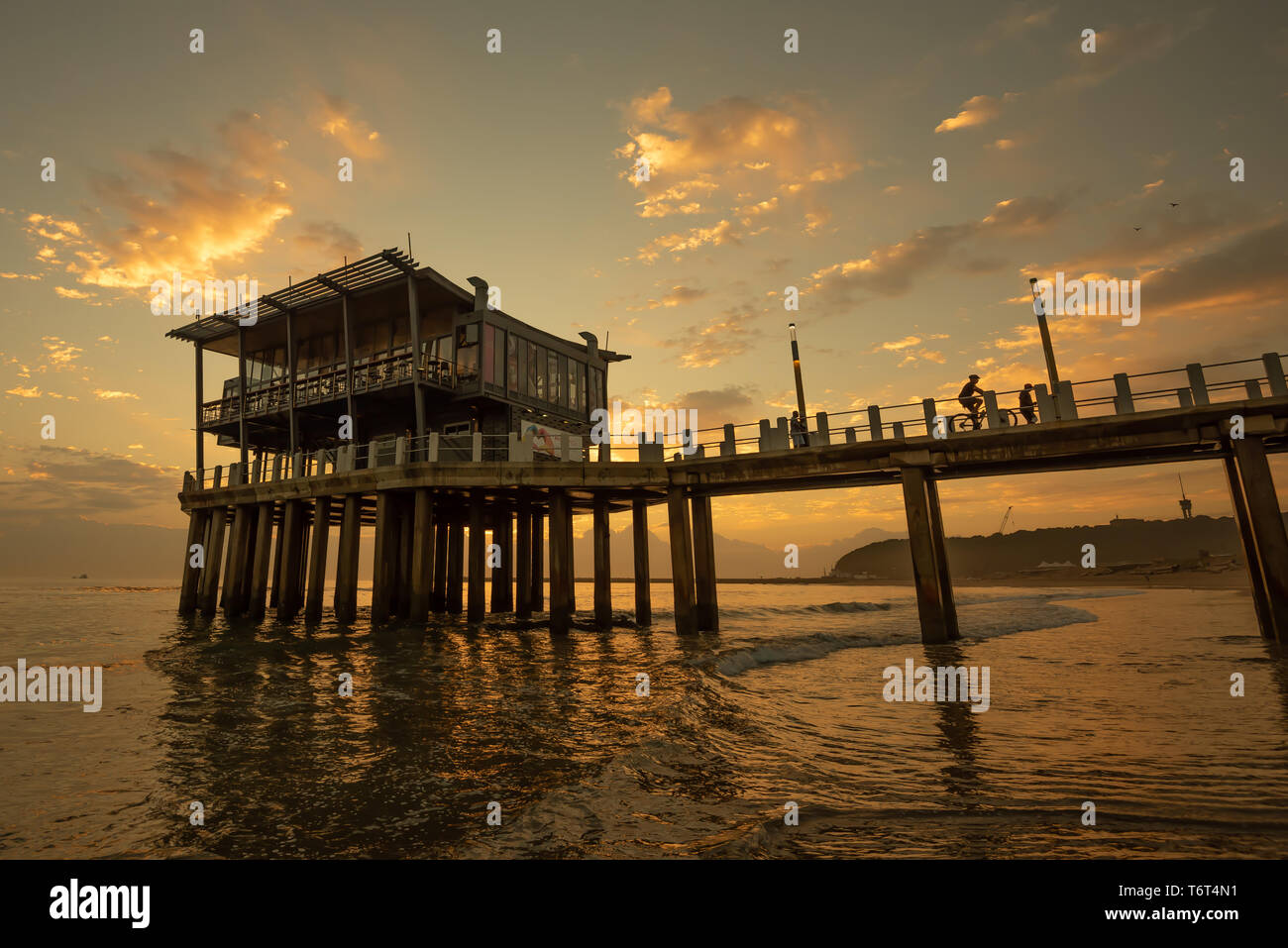 Moyos Pier in Durban, South Africa, silhoetted against the sky at sunrise. Stock Photo