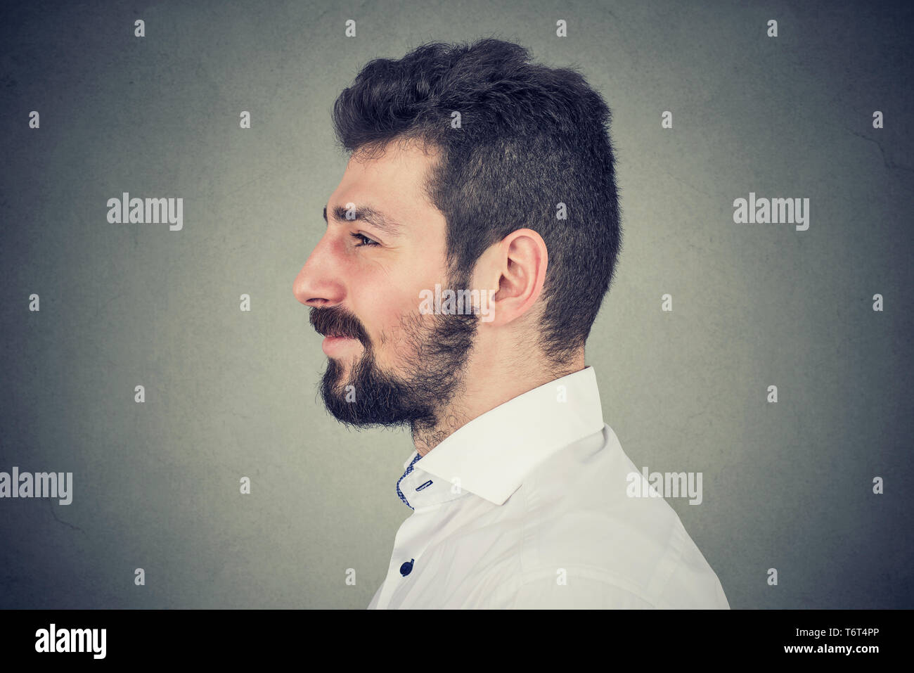 Side view portrait of a young smiling bearded man Stock Photo