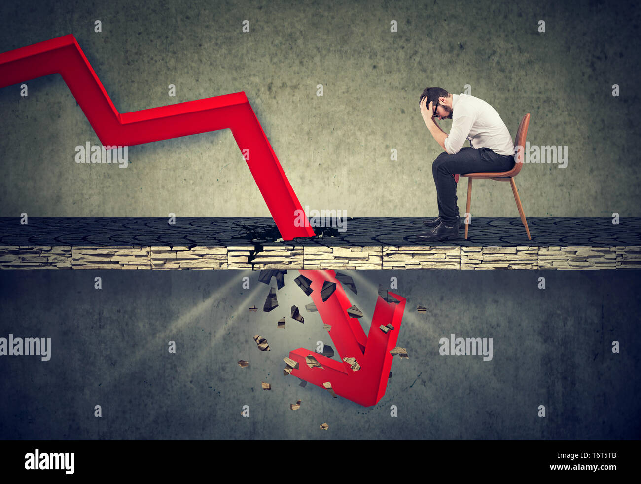 Depressed business man looking down at the falling red arrow going ...