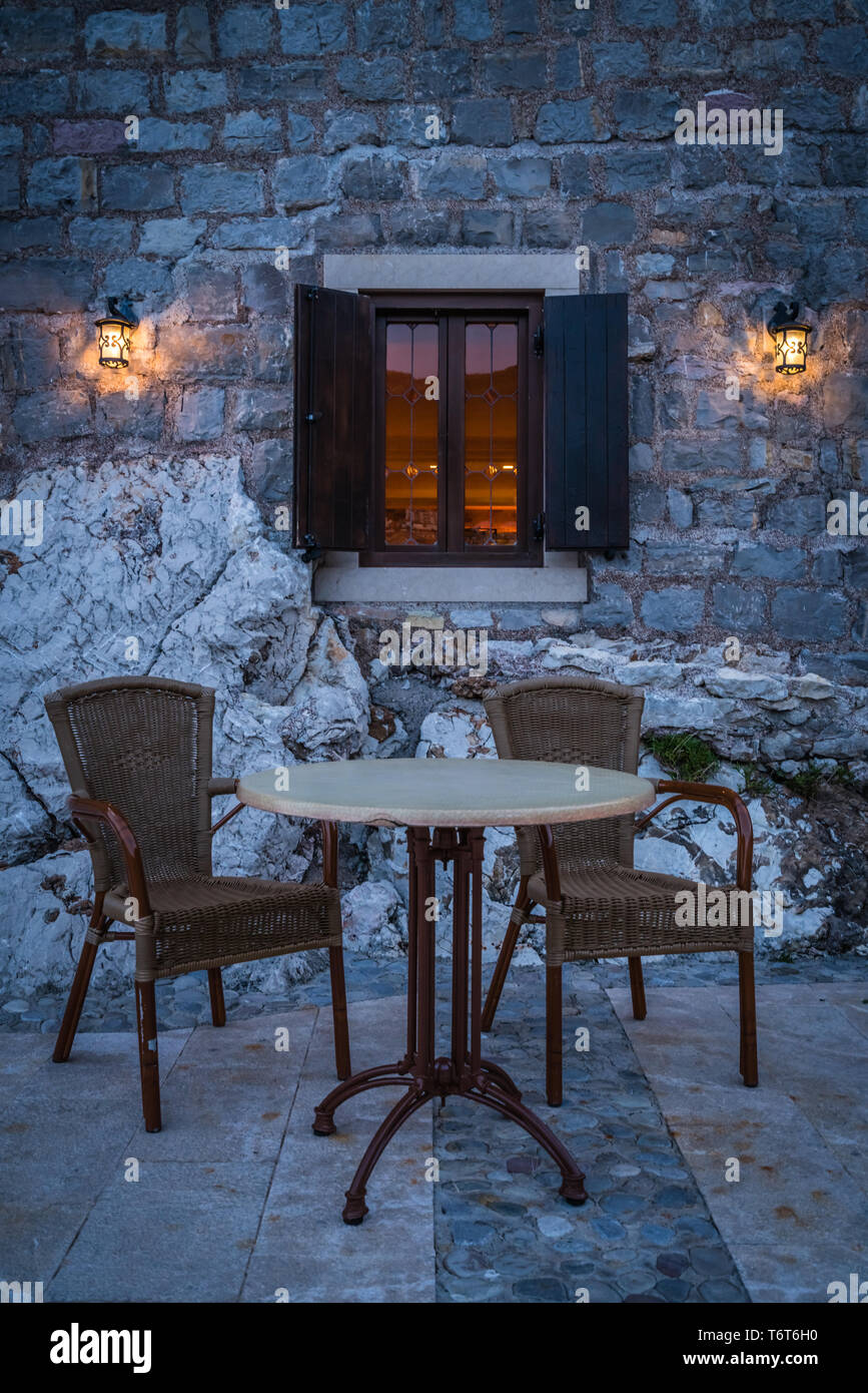 Empty table and wicker chairs outside cafe Stock Photo
